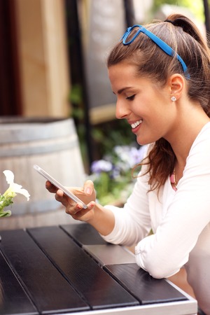 A picture of a happy woman using smartphone in cafeの写真素材