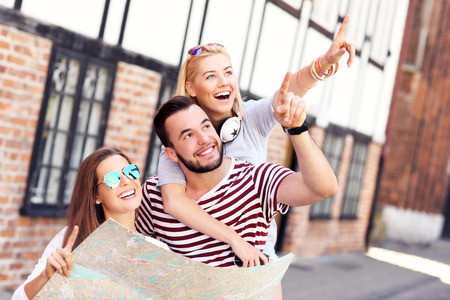 A picture of a group of happy friends sightseeing Gdansk with mapの写真素材