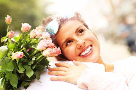 A picture of a pretty woman holding flowers and hugging a manの写真素材