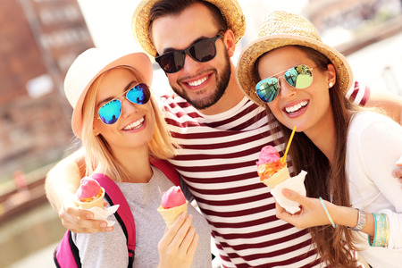 A picture of a group of friends eating ice-cream in front of big wheel in Gdanskの写真素材