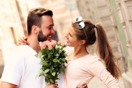A picture of a young romantic couple with flowers in the cityの写真素材