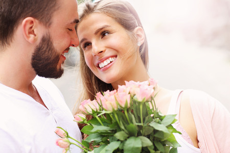 A picture of a young romantic couple with flowers in the cityの写真素材