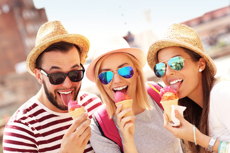 A picture of a group of friends eating ice-cream in front of big wheel in Gdansk