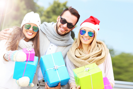 A picture of group of friends holding presents and smiling to the cameraの写真素材