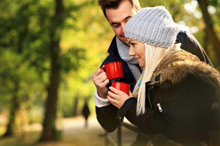 A picture of a young couple drinking tea outdoorsの写真素材