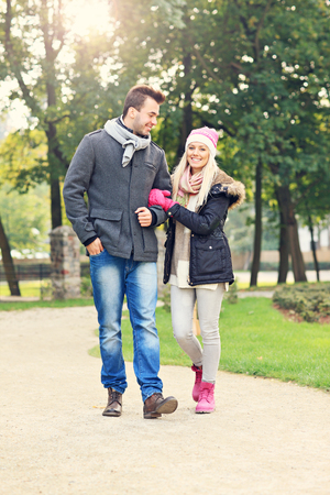 A picture of a young couple walking in the parkの写真素材