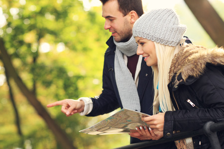 A picture of a young couple with map in the parkの写真素材
