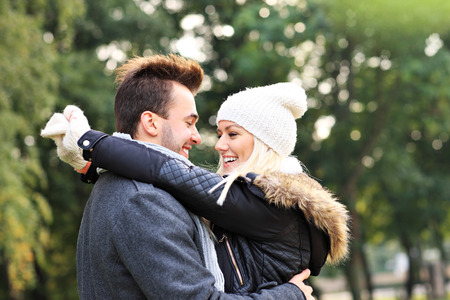 A picture of a young romantic couple hugging in the park in autumnの写真素材