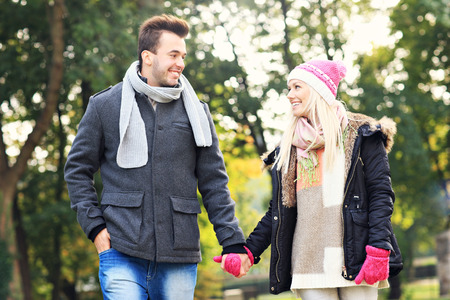 A picture of a young couple walking in the parkの写真素材