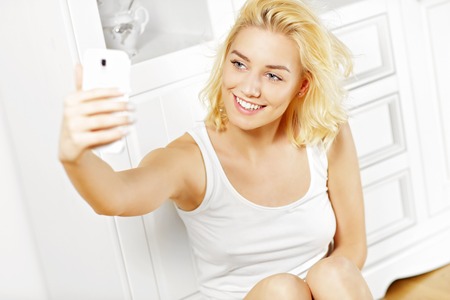 A picture of a happy woman taking selfie at homeの写真素材