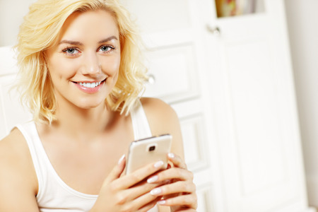 A picture of a young woman texting at homeの写真素材