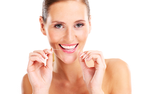 A picture of woman using dental floss over white backgroundの写真素材