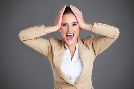 A picture of stressed businesswoman over grey backgroundの写真素材
