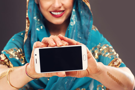 Midsection of oriental woman holding smartphoneの写真素材