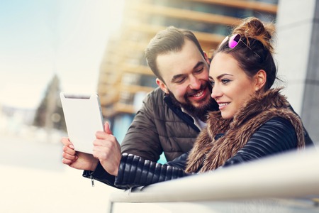 Picture of young couple using tablet outdoorsの写真素材