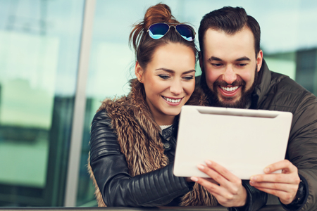Picture of young couple using tablet outdoorsの写真素材