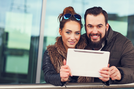 Picture of young couple using tablet outdoorsの写真素材
