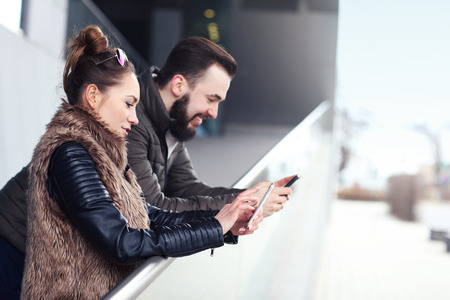 Picture of young couple hanging out in city and textingの写真素材