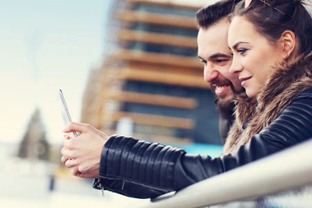 Picture of young couple hanging out in city and textingの写真素材