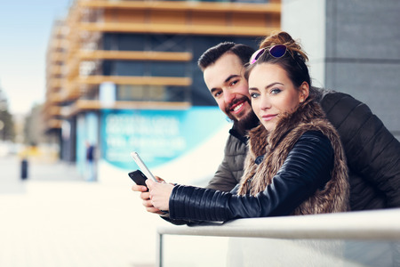 Picture of young couple hanging out in city and textingの写真素材