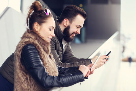 Picture of young couple hanging out in city and textingの写真素材