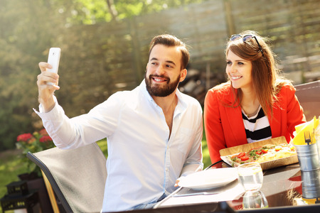 Picture of young couple taking selfie in a restaurantの写真素材