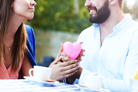 Picture of romantic couple holding hands in cafeの写真素材