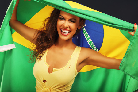 A picture of happy Brazilian fan cheering with flagの写真素材