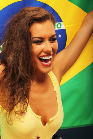 A picture of happy Brazilian fan cheering with flagの写真素材