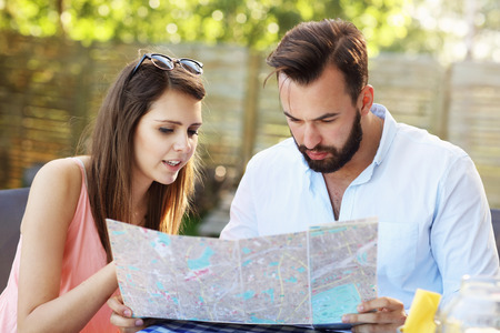 A picture of young couple reading map in cafeの写真素材