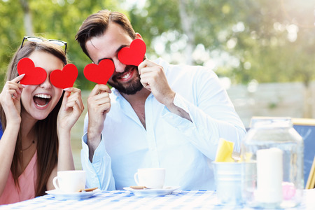 Picture of romantic couple holding hearts cafeの写真素材