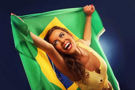 A picture of happy Brazilian fan cheering with flagの写真素材