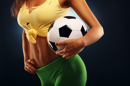 Midsection of fan cheering with footballの写真素材