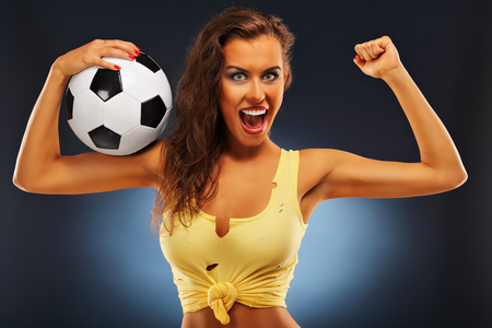 A picture of happy fan cheering with footballの写真素材