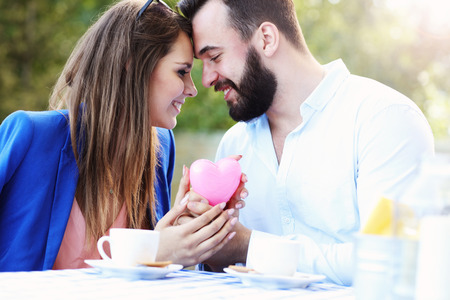 Picture of romantic couple holding hands in cafeの写真素材