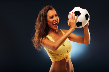 A picture of happy fan cheering with footballの写真素材