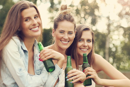 Picture presenting happy group of friends having a beer outdoorsの写真素材