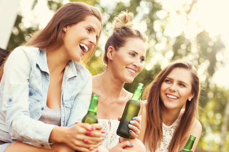 Picture presenting happy group of friends having a beer outdoorsの写真素材