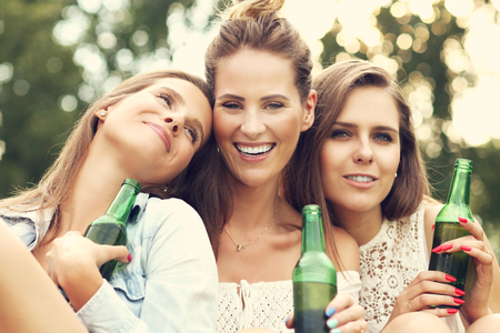 Picture presenting happy group of friends having a beer outdoorsの写真素材