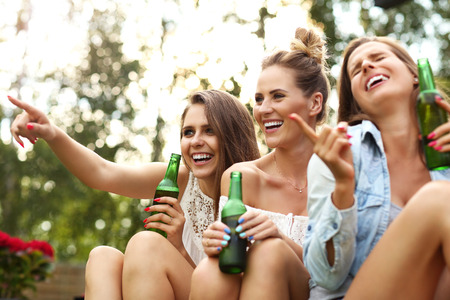 Picture presenting happy group of friends having a beer outdoorsの写真素材