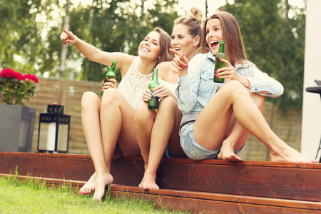 Picture presenting happy group of friends having a beer outdoorsの写真素材