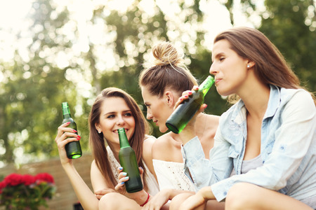 Picture presenting happy group of friends having a beer outdoorsの写真素材