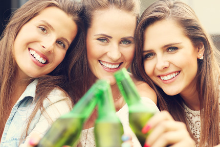 Picture presenting happy group of friends having a beer outdoorsの写真素材