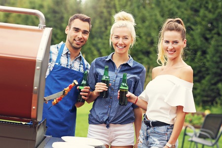 Picture presenting group of friends having barbecue partyの写真素材