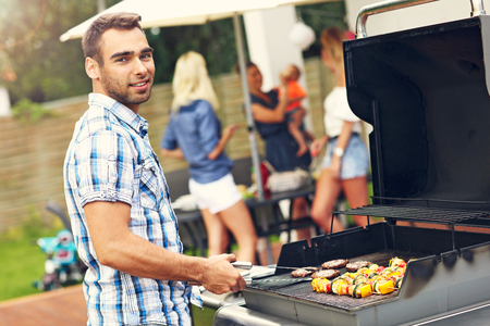 Picture presenting group of friends having barbecue partyの写真素材