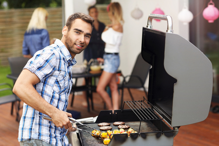 Picture presenting group of friends having barbecue partyの写真素材