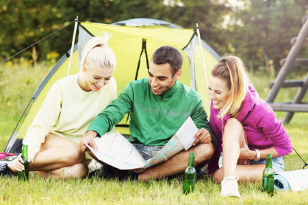 Picture of group of friends camping in forest and looking at mapの写真素材