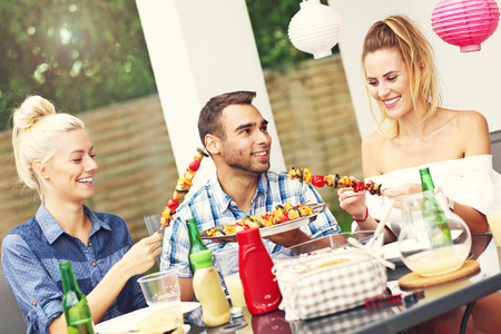 Picture presenting group of friends having barbecue partyの写真素材
