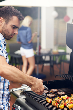 Picture of young man grilling foodの写真素材