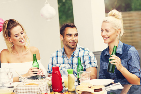 Picture presenting group of friends having barbecue partyの写真素材